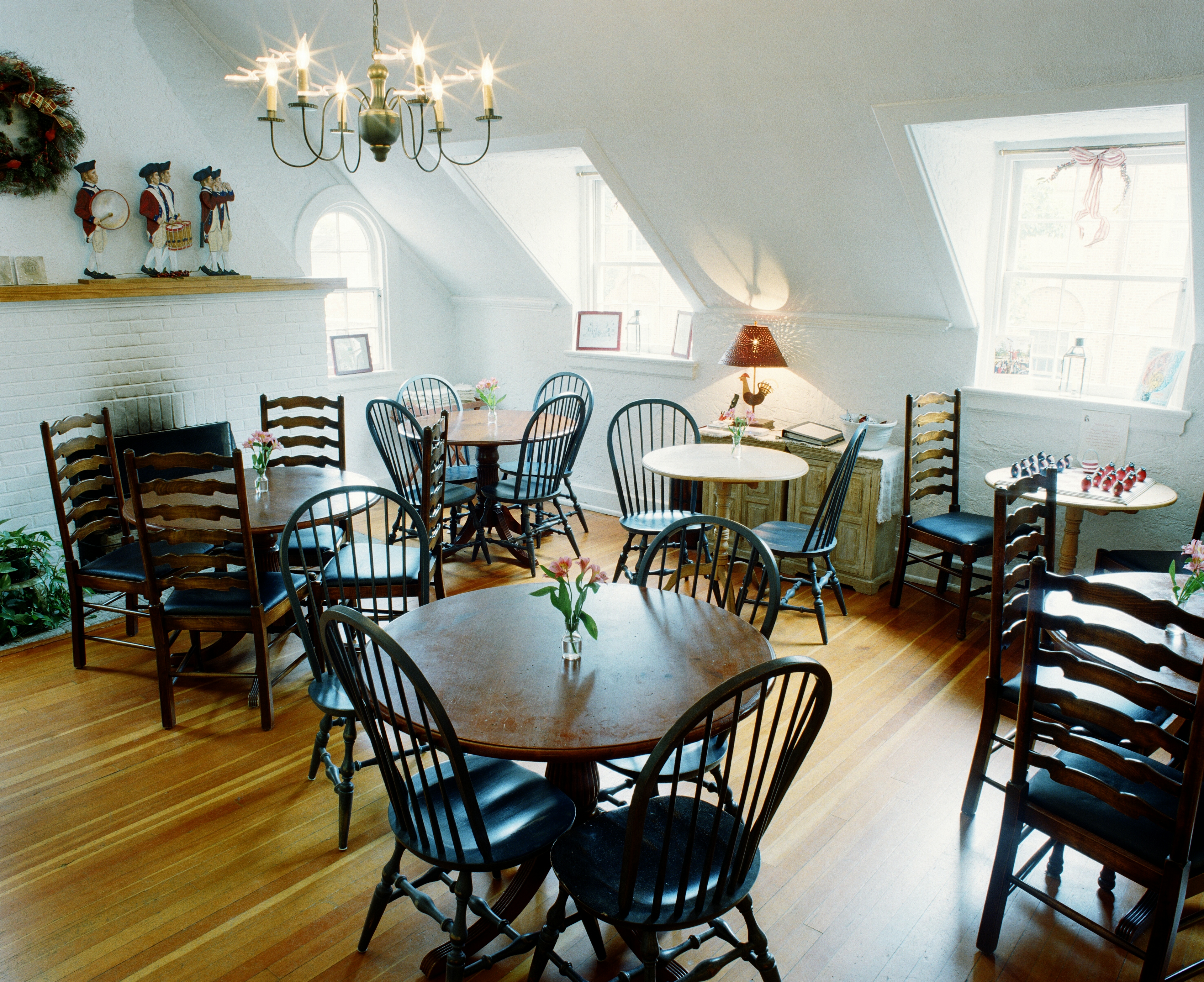 Dining room with round tables, tall back chairs and wood floors