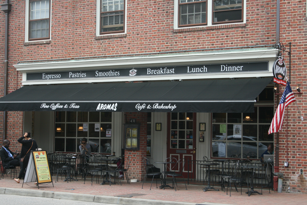 Black awning in front of red brick eatery