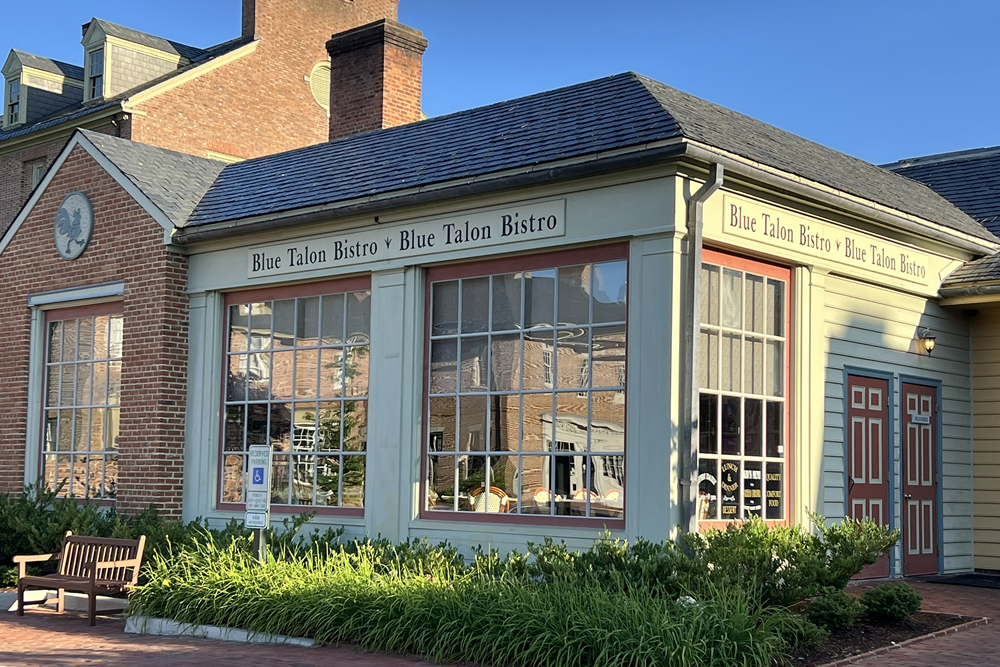 Wood painted cream Store front with large windows a overhead sign for Blue Talon Restaurant