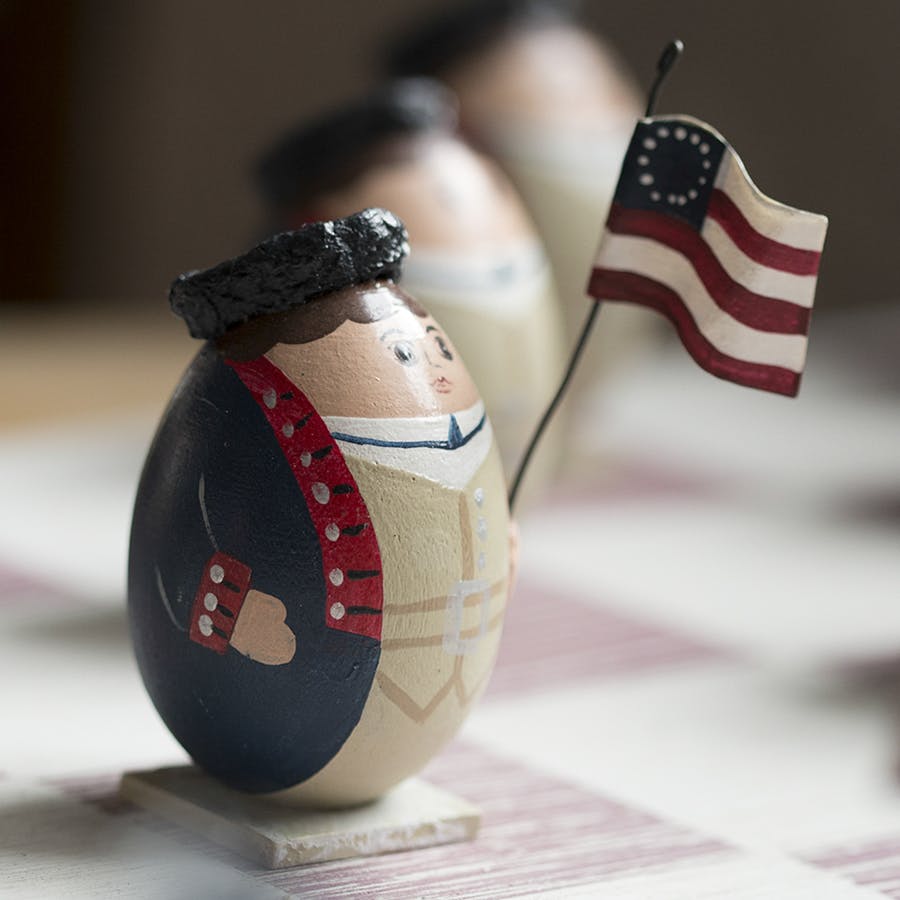 Egg painted like a colonial militia soldier holding a flag.