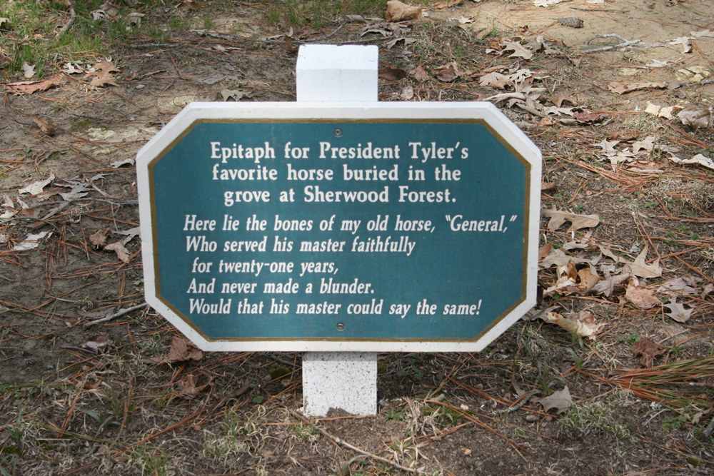 Epitaph for President Tyler's favorite horse on a wood sign painted in white on a teal background.