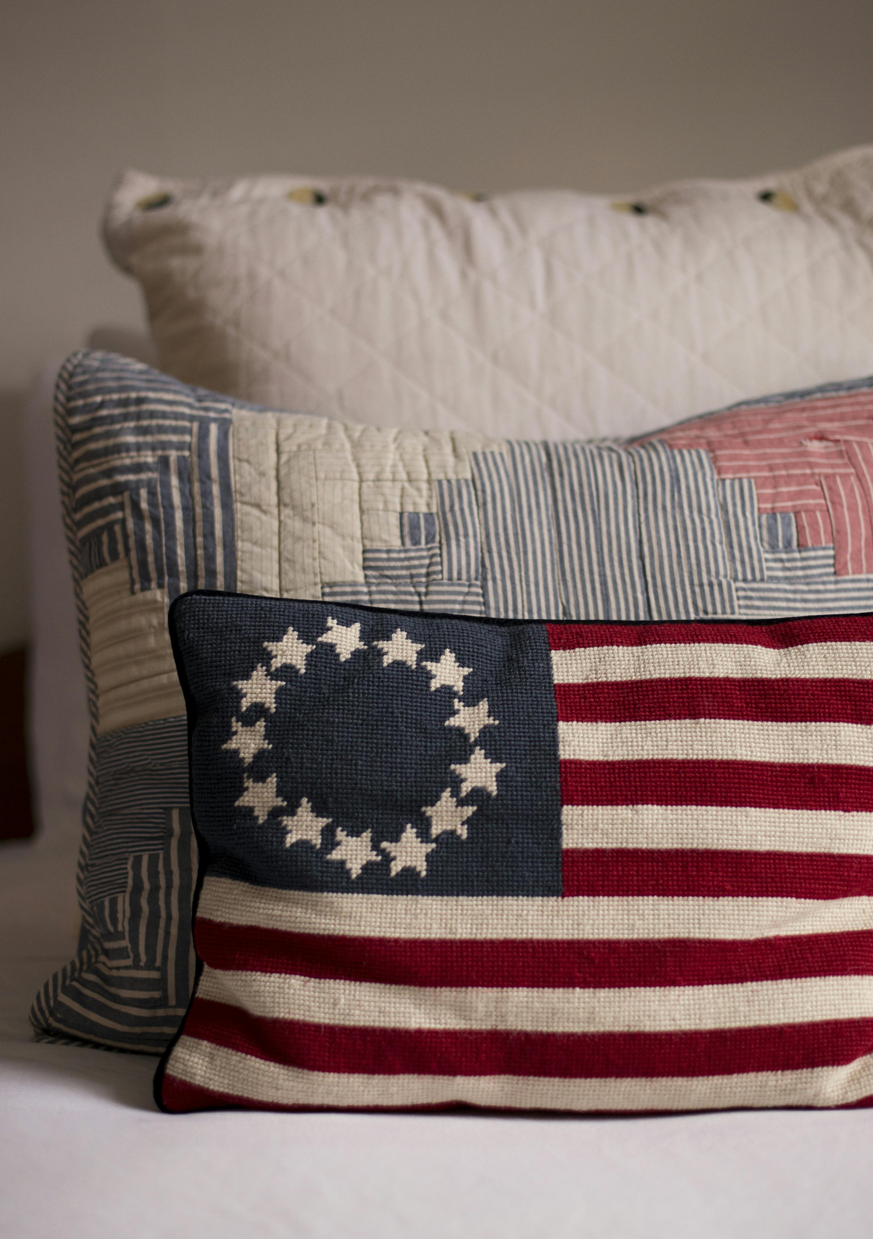 Decorative throw pillows in red white and blue on bed