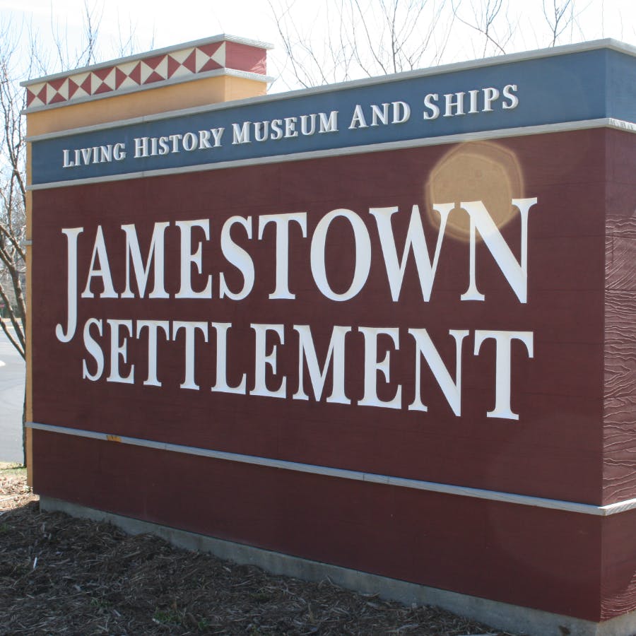 A red and blue sign that says Jamestown Settlement, Living History Museum and Ships