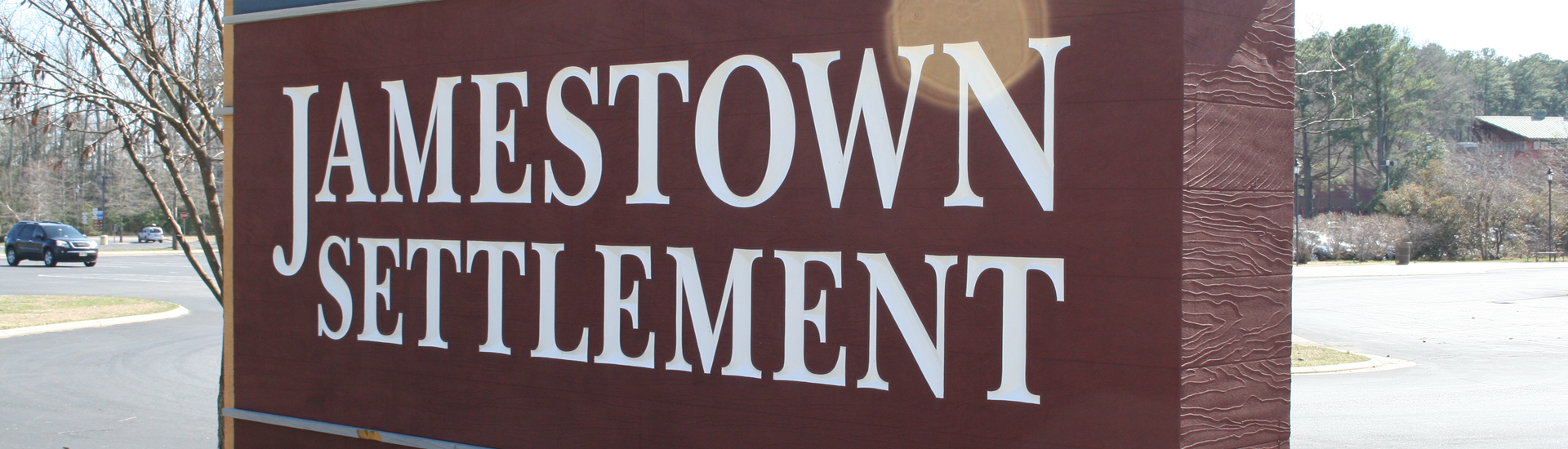 A red sign with the words Jamestown Settlement in white.