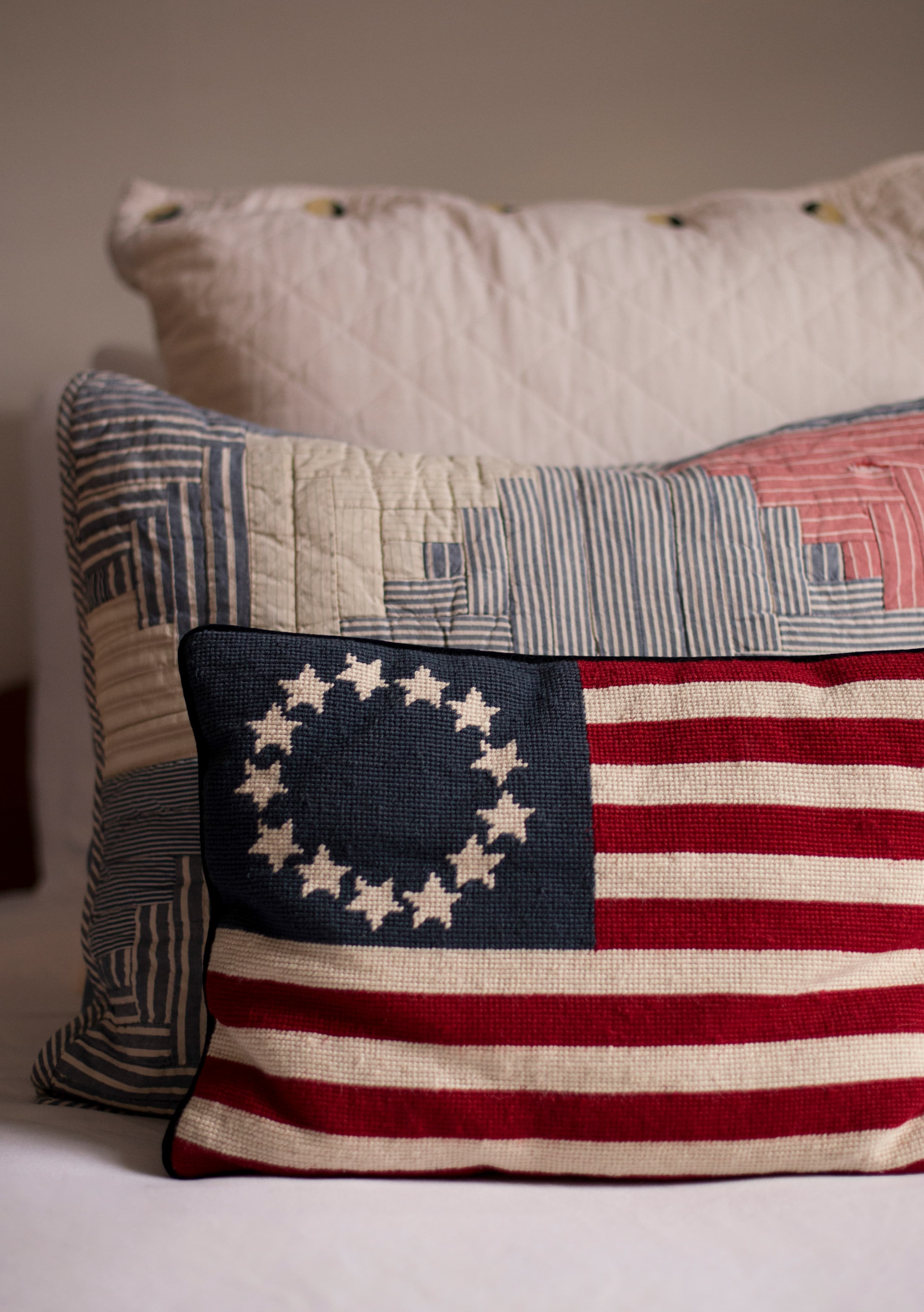 Decorative throw pillows in red white and blue on bed