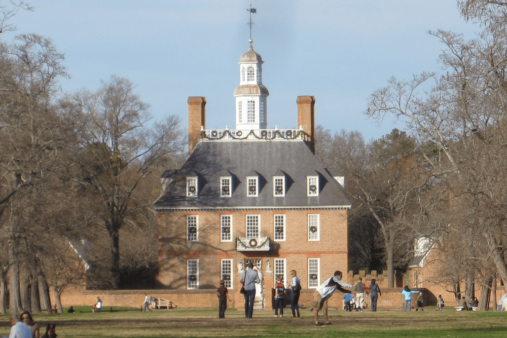 Yellow brick, 3 story hip roof with two yellow brick chimneys and white look out cap on top