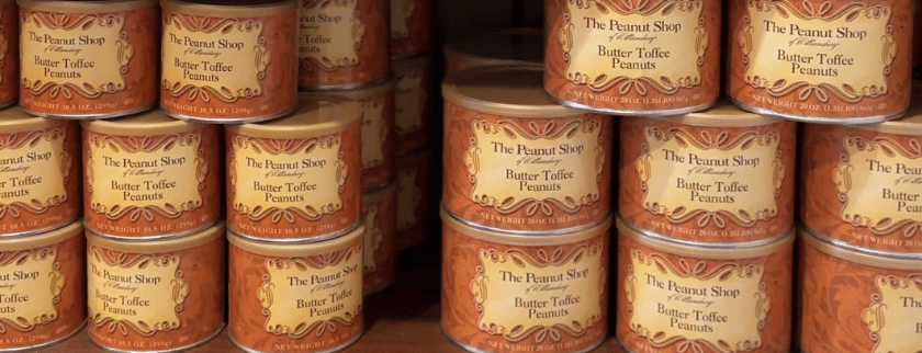 Cans of Butter Toffee Peanuts stacked on a shelf at The Peanut Shop.