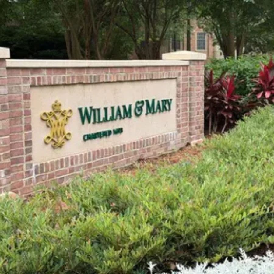 Sign for William & Mary, established 1693, with landscaping.