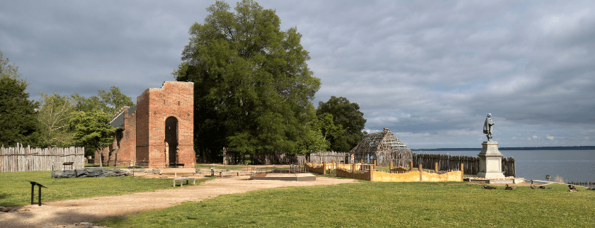 Historic site featuring a brick ruin, a statue, and a waterfront view under a cloudy sky. Historic site featuring a brick ruin, a statue, and a waterfront view under a cloudy sky.