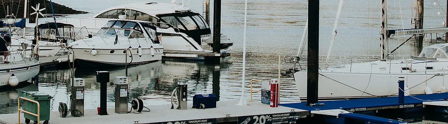 A dock with several boats moored and fuel pumps visible. A dock with several boats moored and fuel pumps visible.