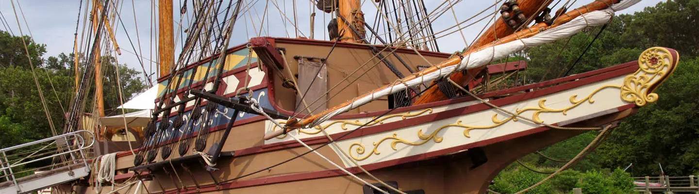 A close-up view of a ship's bow adorned with intricate designs and rigging. A close-up view of a ship's bow adorned with intricate designs and rigging.