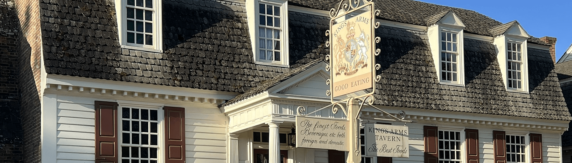 Tavern signs in front of white clapboard building