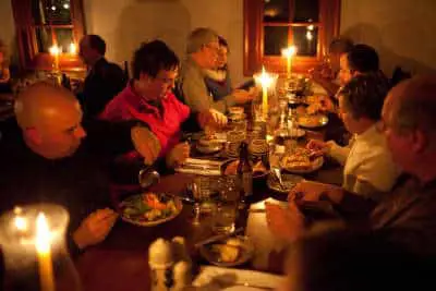 A group of people enjoying a candlelit dinner at a long table.