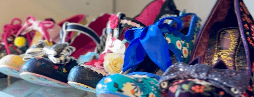 A colorful display of various stylish women's shoes with bows and floral patterns.