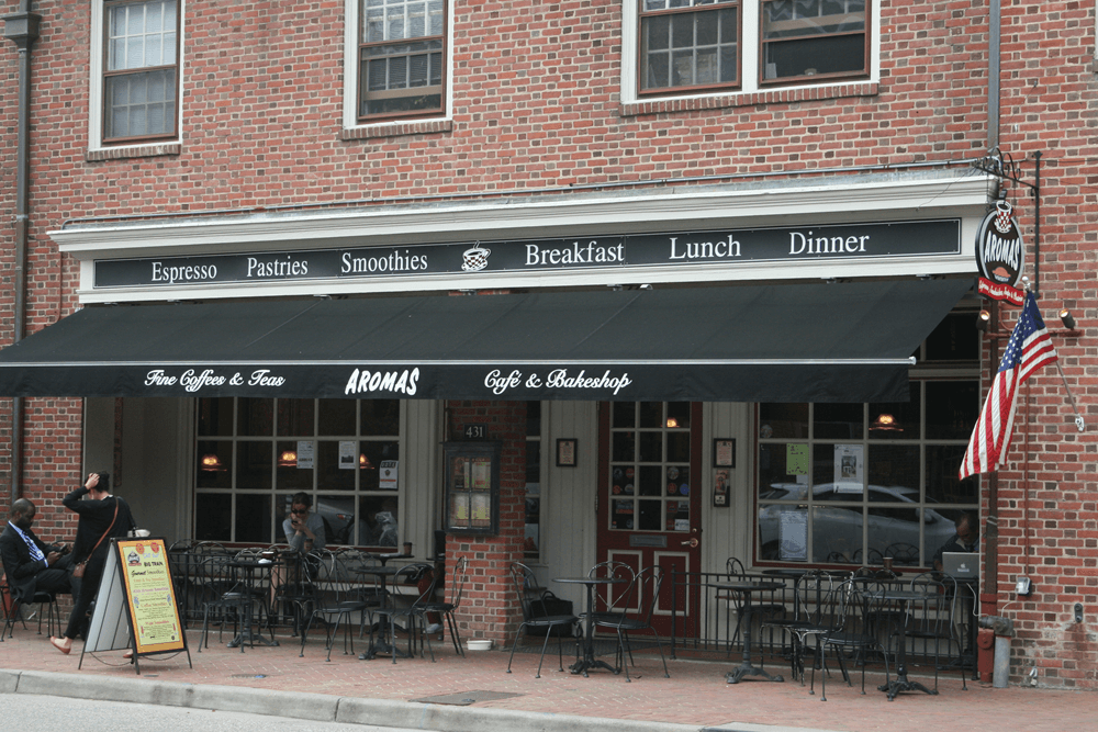 Black awning in front of red brick eatery