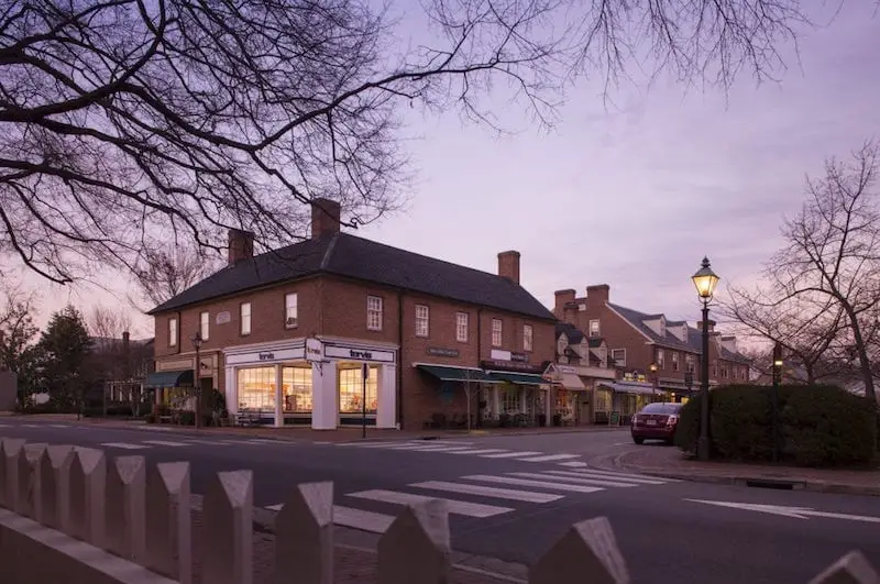A quaint street scene at dusk featuring brick buildings and lampposts.