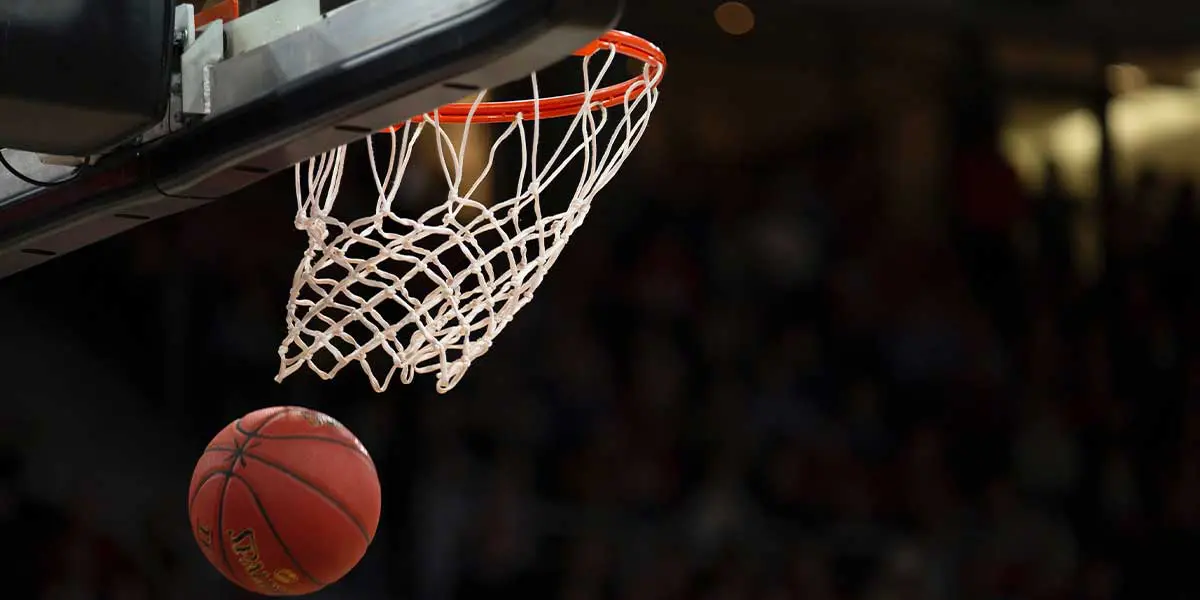 A basketball is about to enter a hoop.