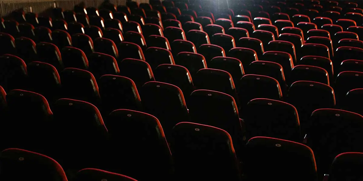 A row of empty red theater seats.