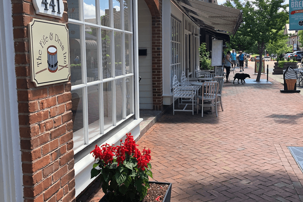 Exterior signage of Fife and Drum Inn on street with other stores