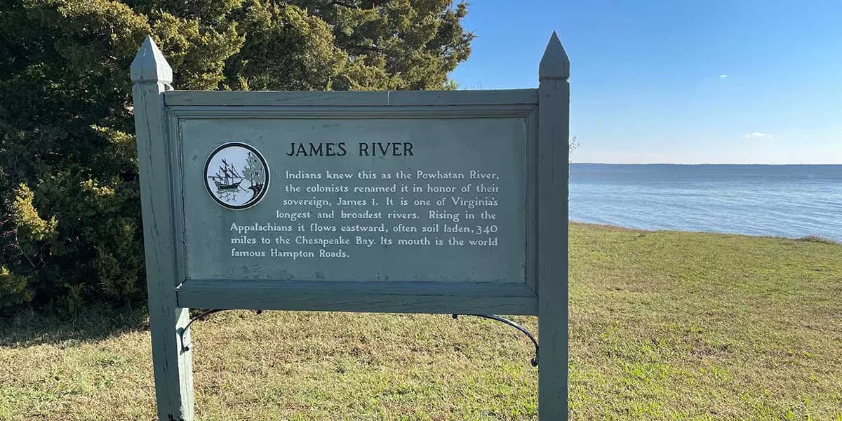 Sign detailing the James River, with the water visible in the background.