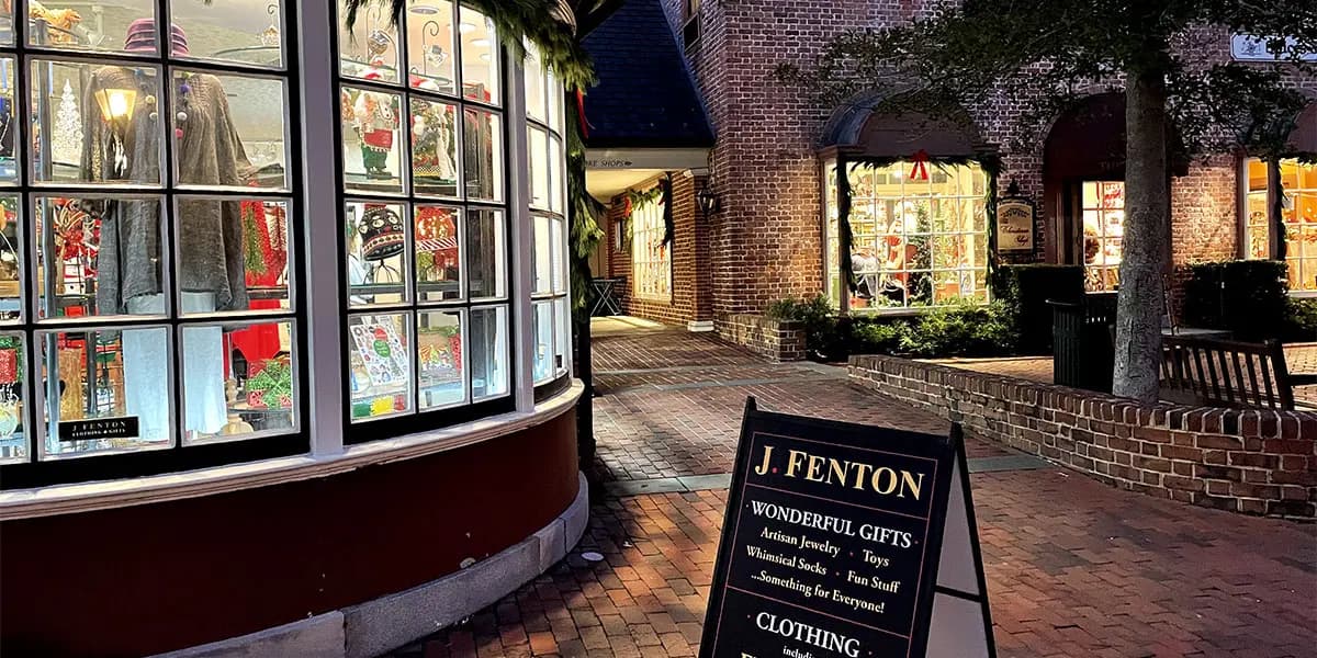 A festive storefront displays gifts and decorations under warm evening lights.